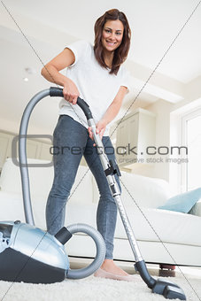 Woman holding vacuum cleaner smiling