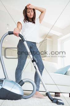 Tired woman with vacuum cleaner