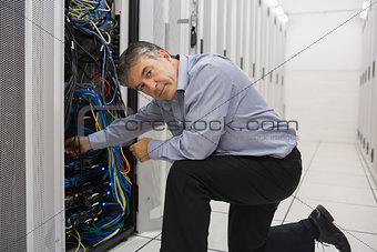 Technician kneeling and repairing a server
