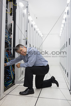 Technician kneeling and repairing a server