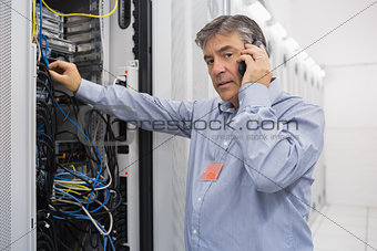 Technician working on server and phoning