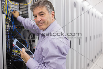 Technician using tablet pc to check the servers