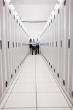 Technicians standing at end of server corridor