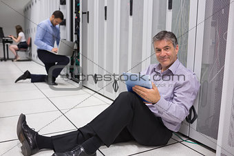 Smiling technician working on digital tablet on the floor