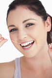 Smiling woman using dental floss