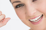 Smiling woman using dental floss