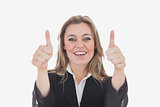 Happy business woman gesturing thumbs up