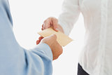 Businessman handing over envelop to coworker
