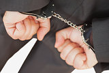 Businessman with handcuffs clencing fists