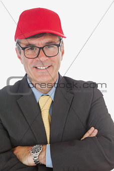 Businessman with arms crossed wearing baseball cap