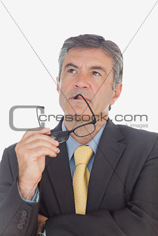 Thoughtful businessman with glasses looking up