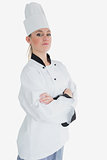 Female chef in uniform standing with arms crossed