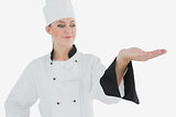 Chef in uniform looking at invisible product
