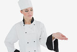 Femal in chefs uniform looking at invisible product