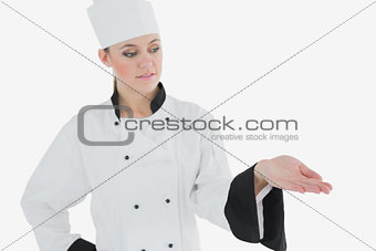 Femal in chefs uniform looking at invisible product