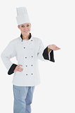 Female chef with hand on waist holding invisible product