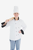 Happy female chef in unifrom holding rolling pin