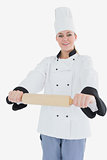 Woman in chef clothing holding rolling pin