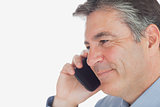 Mature businessman smiles while on call