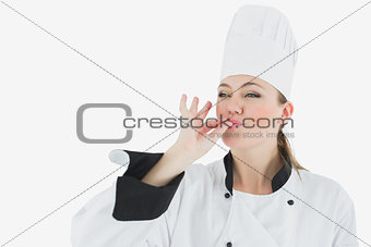 Female chef in uniform blowing a kiss