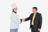 Businessman and female chef shaking hands