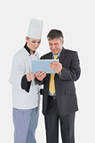 Female chef and businessman using digital tablet