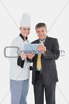 Female chef and businessman with digital tablet