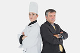 Businessman and chef standing back to back