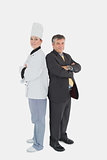 Businessman and female chef standing back to back