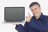 Mechanic with laptop showing thumbs up sign