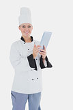 Happy female chef holding digital tablet
