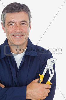 Mechanic with arms crossed holding pliers