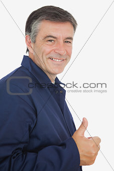Happy mature mechanic showing thumbs up sign