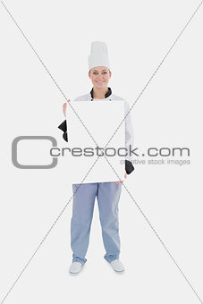 Female chef holding blank billboard