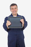 Mature mechanic displaying digital tablet