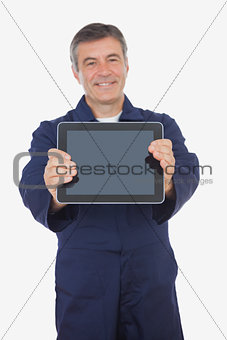 Mature mechanic showing digital tablet