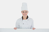 Happy female chef with billboard