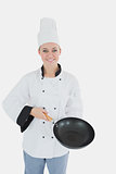 Female chef holding empty frying