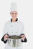 Happy female chef holding kitchen utensil