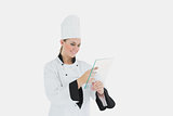 Female chef using glass tablet