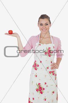 Young woman holding tomato