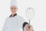 Female chef holding wire wisk