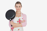 Portrait of woman in apron holding frying pan