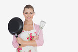 Young woman holding frying pan and spatula