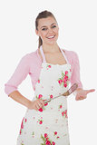 Young woman in apron holding spatula