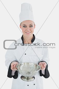 Female chef holding colander