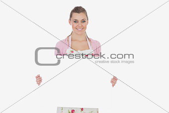 Young woman holding blank billboard