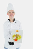 Chef in uniform offering plate of healthy food
