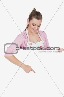 Maid in apron pointing at billboard
