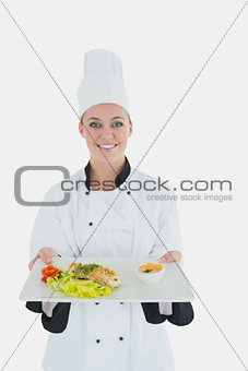 Female chef holding plate of healthyt meal